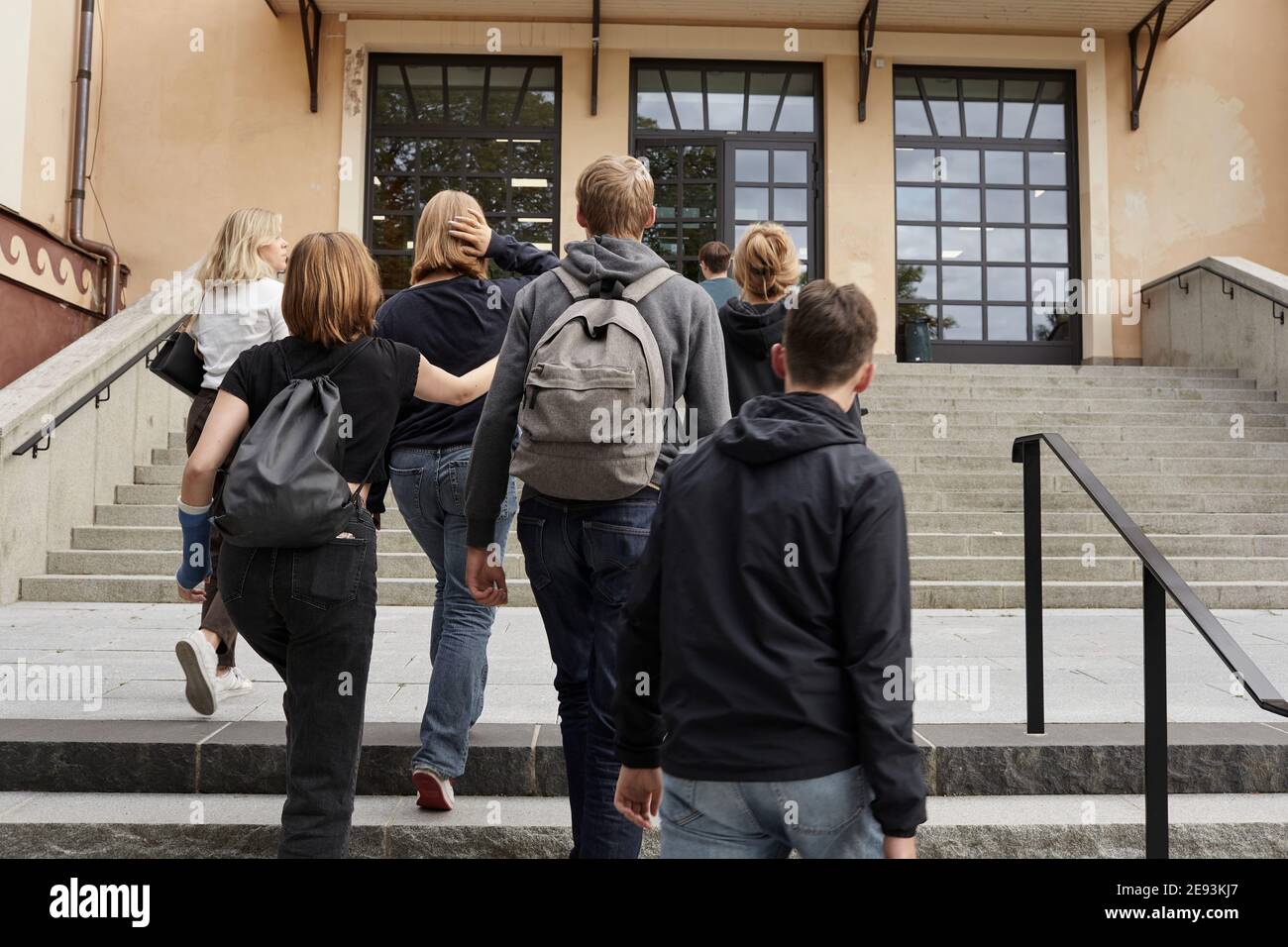 Rear view of teenagers in front of school Stock Photo