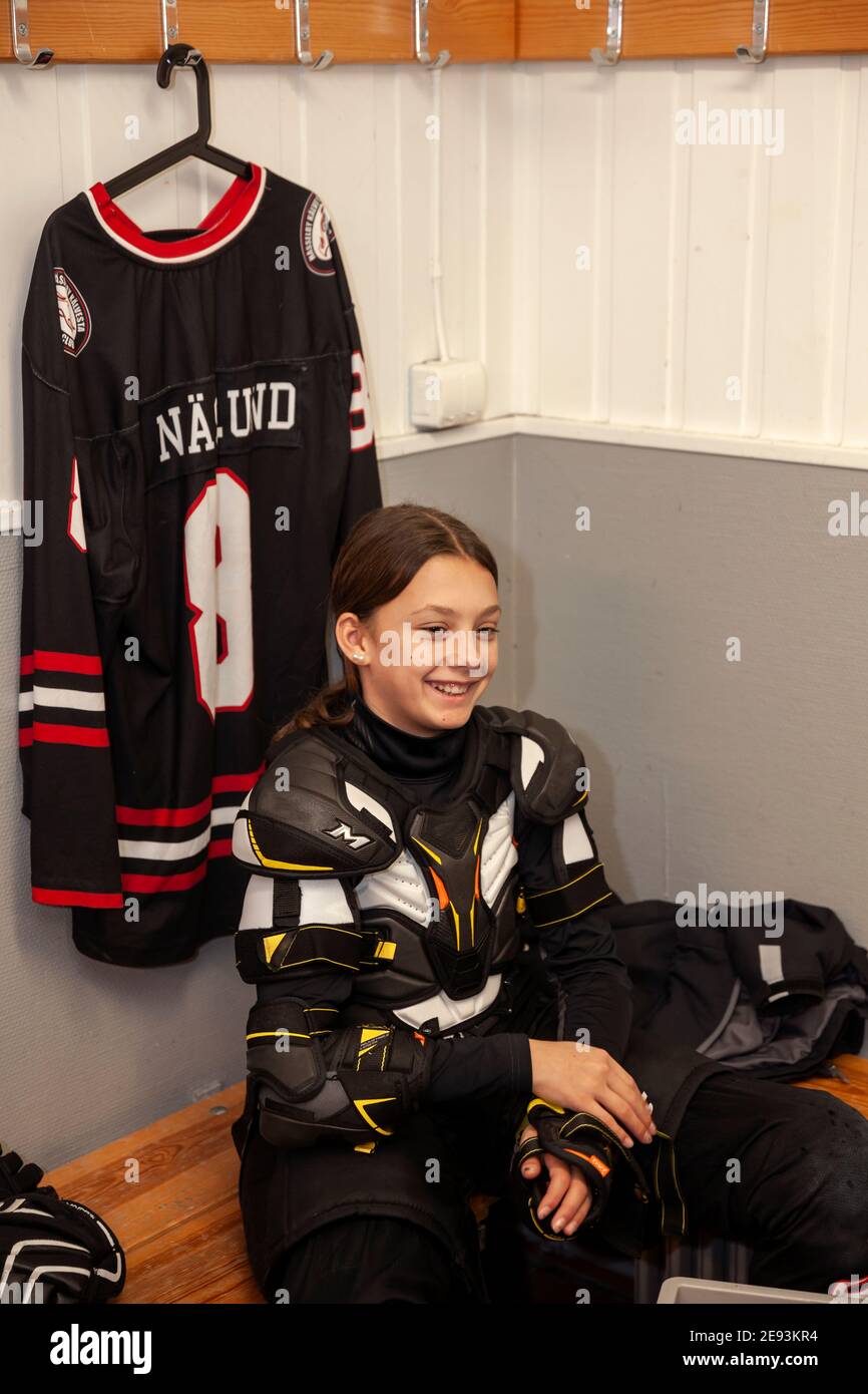 Girl hockey player dressing in locker room Stock Photo - Alamy
