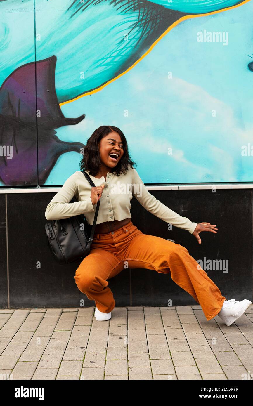 Happy young woman dancing on street Stock Photo - Alamy
