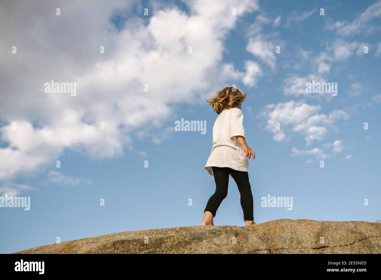 Low angle view of girl walking on rocks Stock Photo