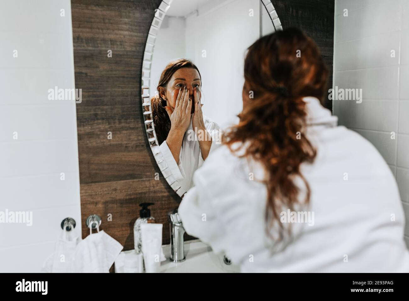 Woman applying moisturizer on her face Stock Photo