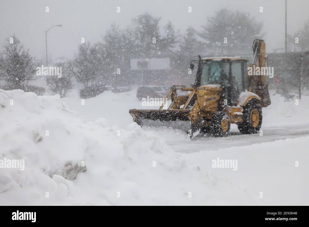NORWALK, CT, USA-FEBRUARY 1, 2021:  Snow plow machinery  during snow storm  day cleaning parking lot on shopping plaza Stock Photo