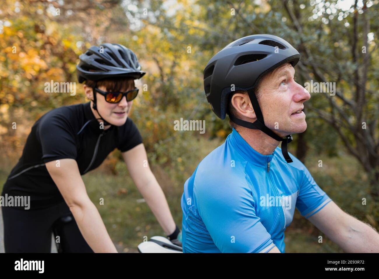 Visually impaired female triathlete training on tandem bicycle with her guide and coach Stock
