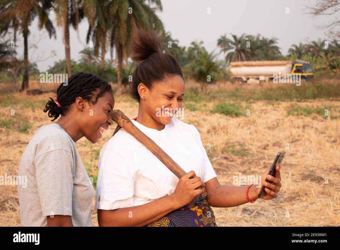 two women viewing a mobile phone at a farmland Stock Photo