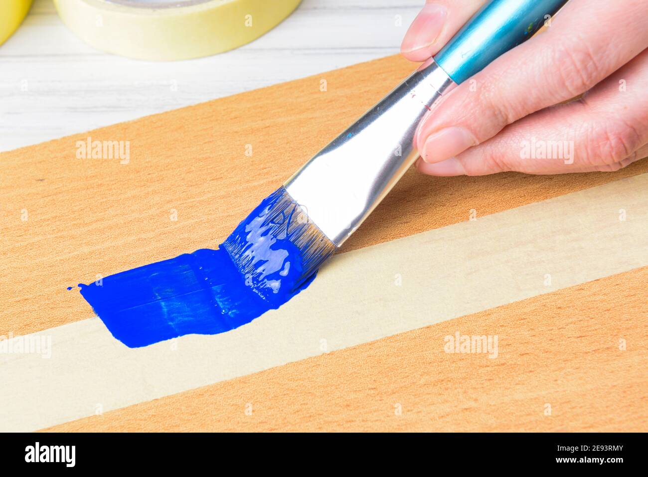 Using protective masking tape when painting with brush and blue paint