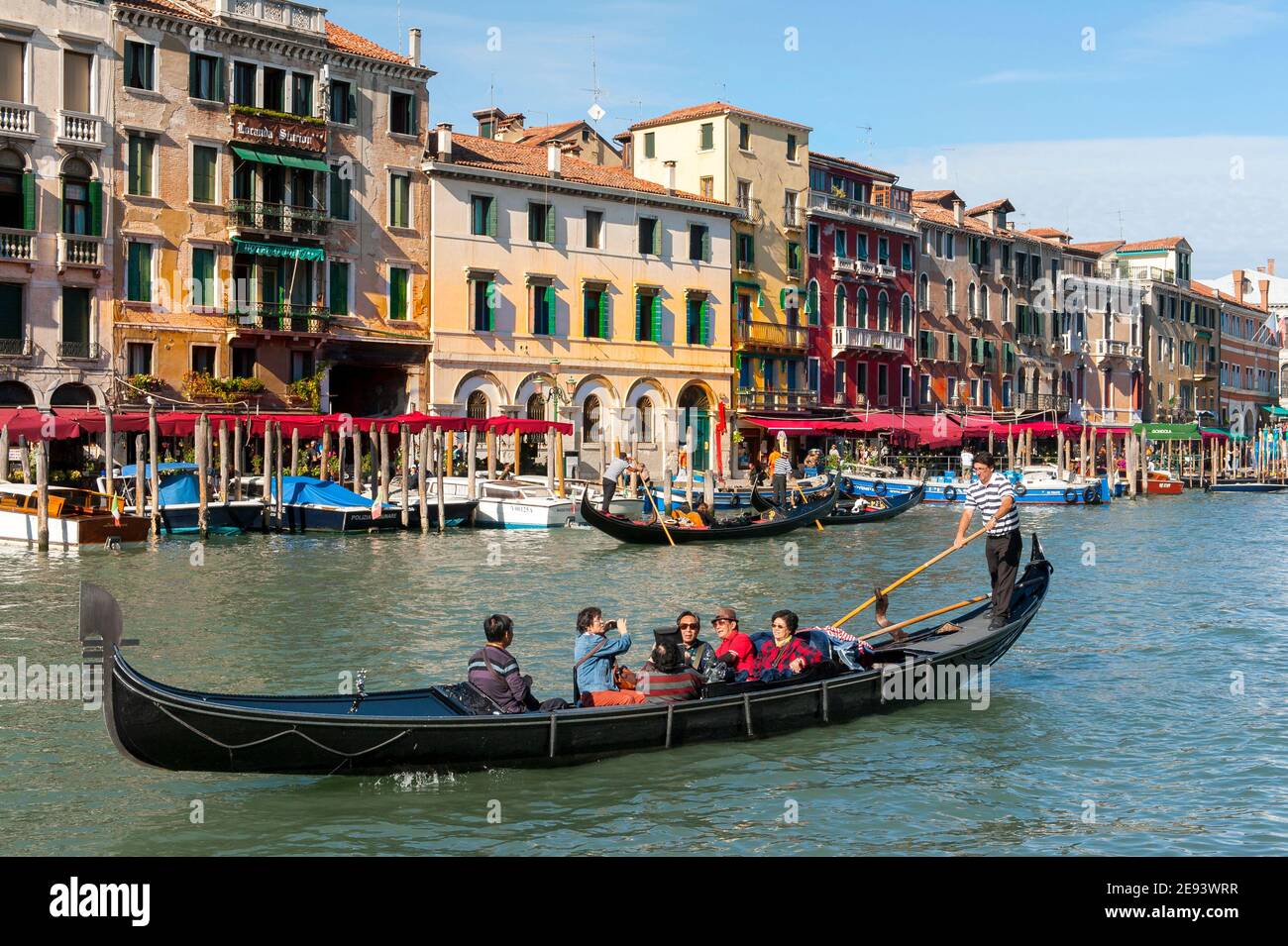 Tourists enjoying a gondola ride on the Grand Canal in the beautiful ...