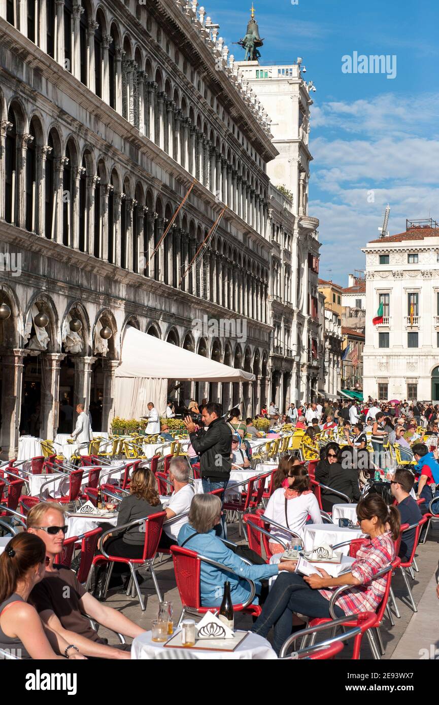 Tourists dining outside a restaurant in St Mark's Square in the beautiful city of Venice, Italy. Stock Photo