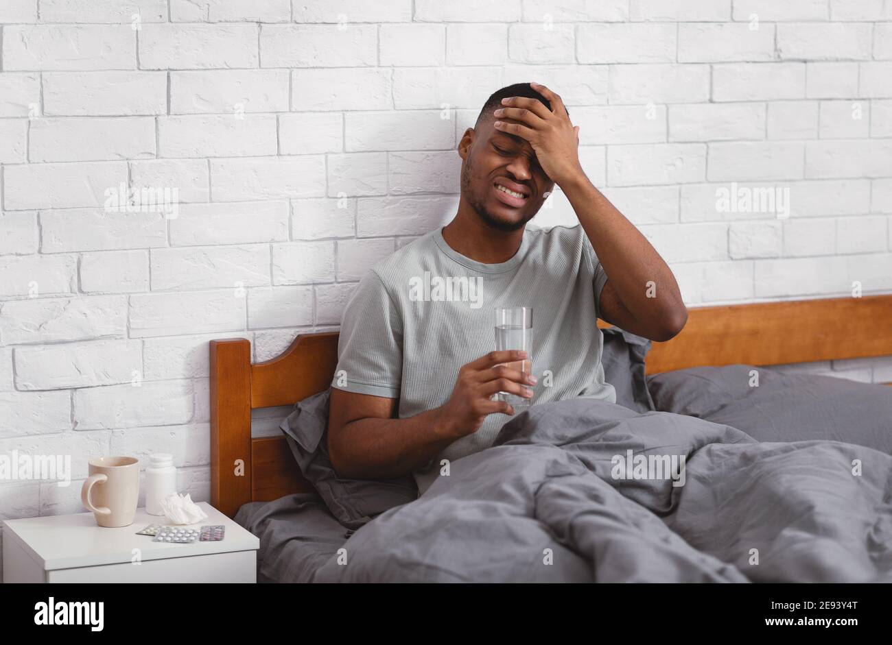 Sick Black Man Having Fever During Influenza Illness In Bedroom Stock Photo