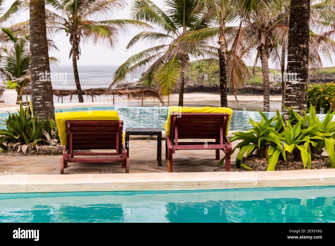 Two deckchairs along the pool facing the Indian Ocean on Watamu Beach in Kenya Stock Photo