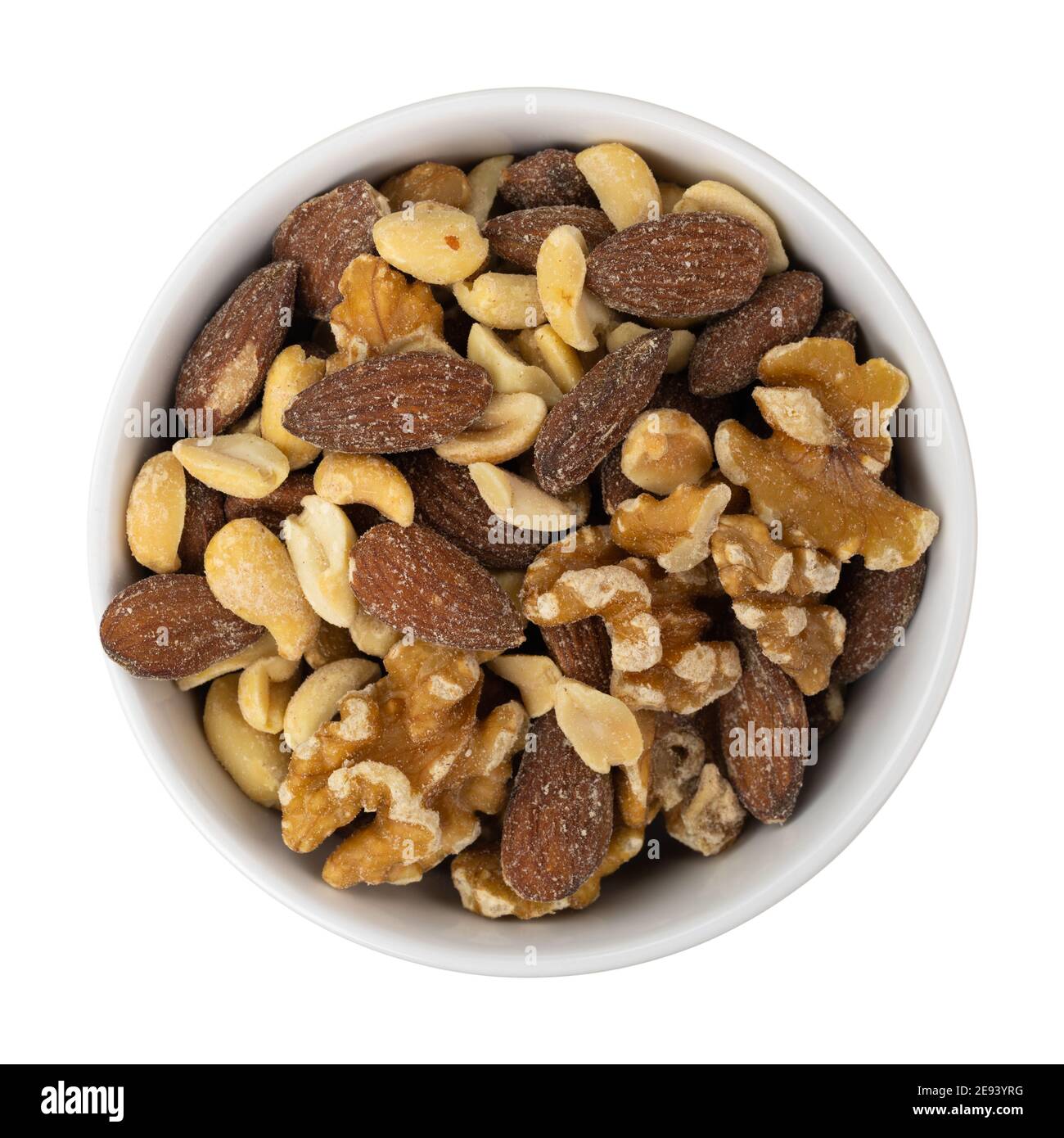 Assorted nuts in a white bowl on a red background top view. Stock Photo