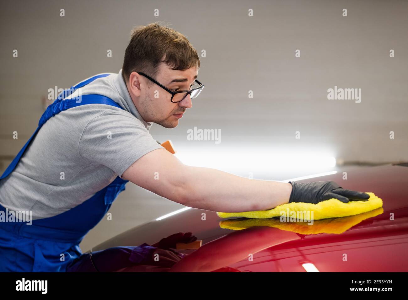 Man polishing cleaning car with microfiber cloth, detailing or valeting