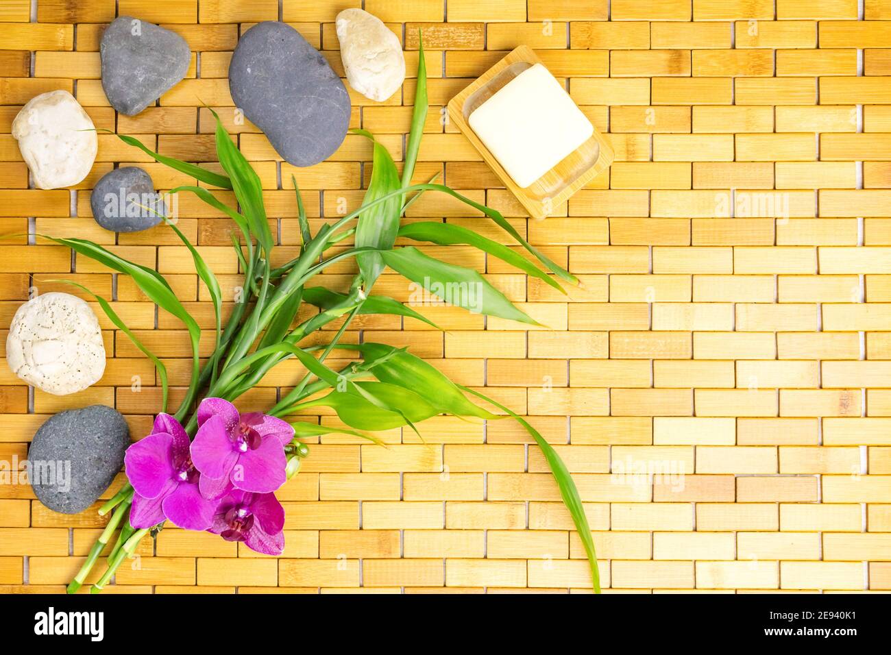 Spa, zen, massage concept. Bamboo leaves, bath soap dish, white black stones, orchid Stock Photo