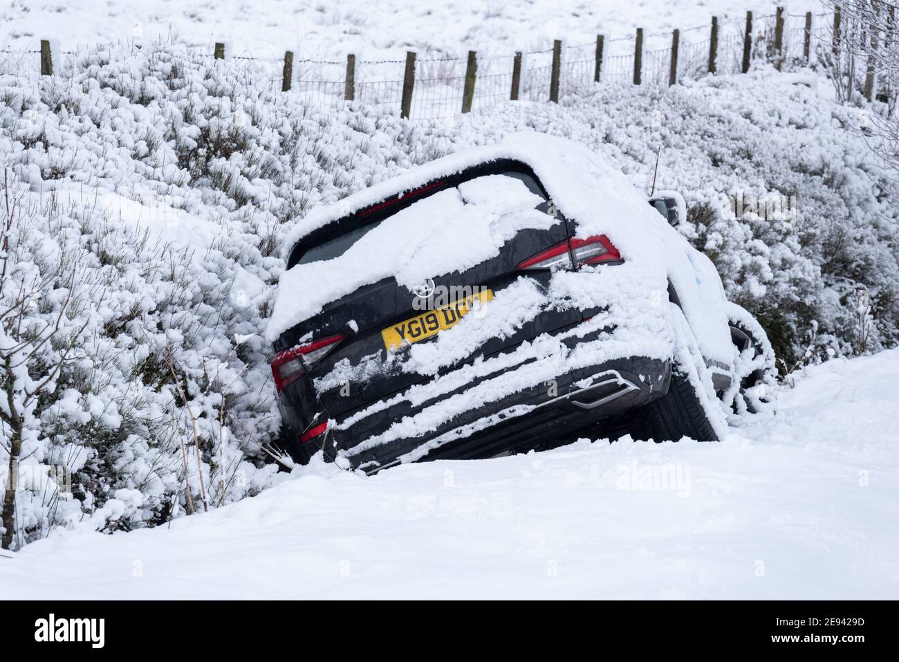 A car abound in a ditch after skidding off the road in treacherous conditions Stock Photo