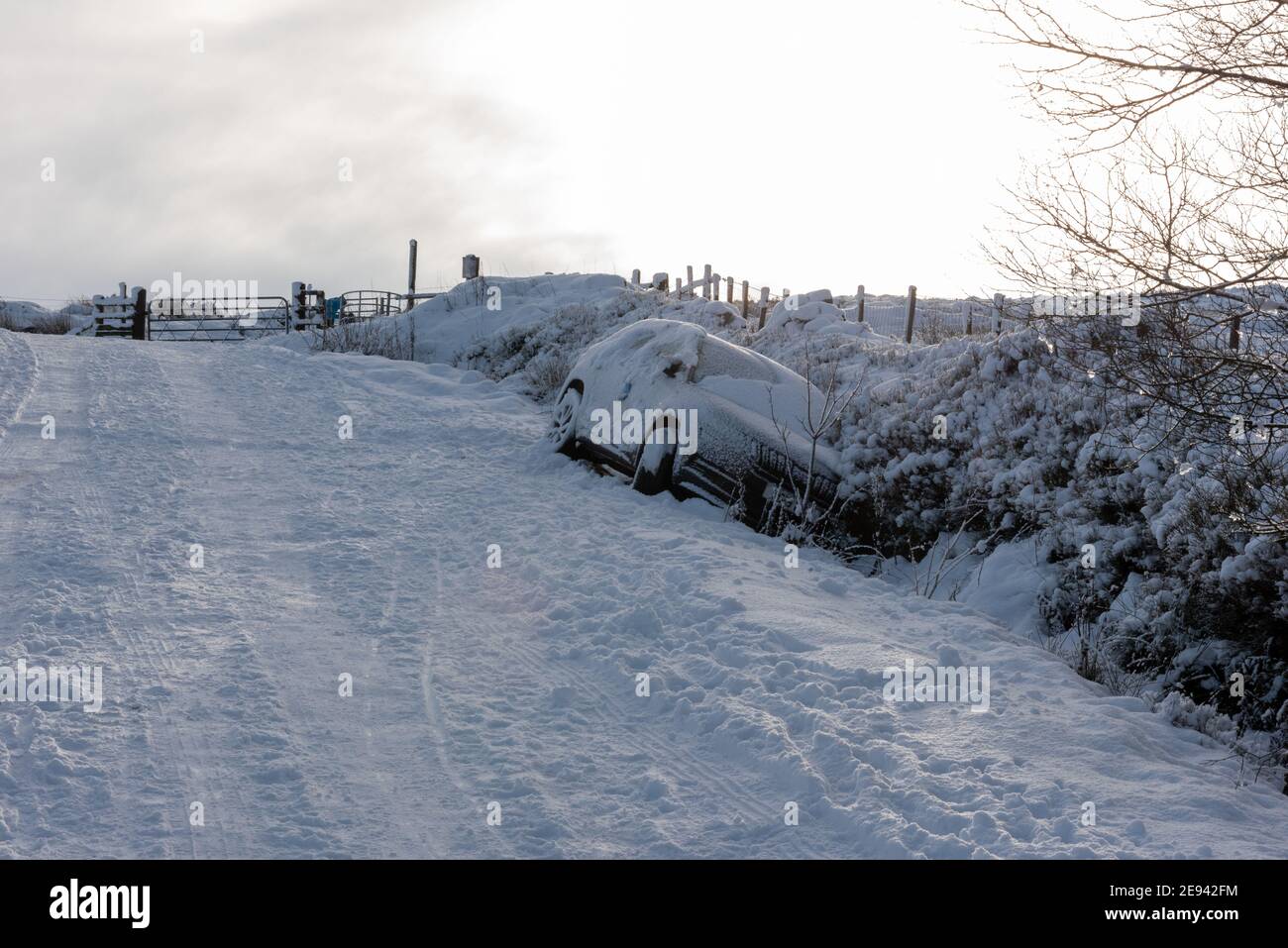 A car abound in a ditch after skidding off the road in treacherous conditions Stock Photo