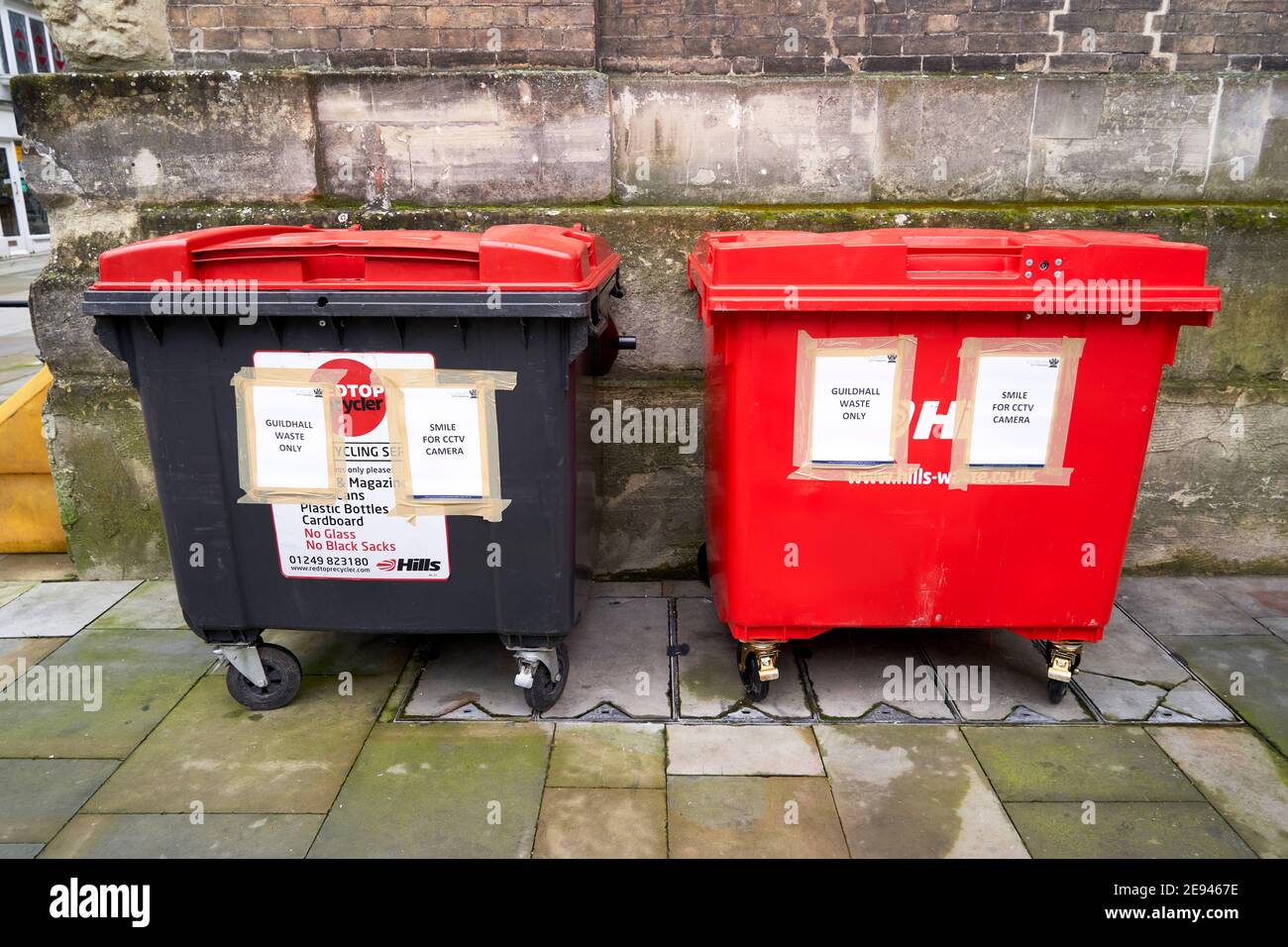 Recycling wheelie bins with notices warning of CCTV surveillance to