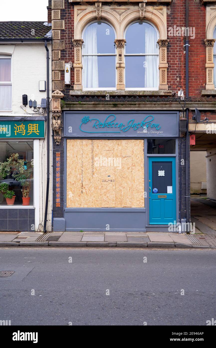 Small business closed down with windows boarded up Stock Photo