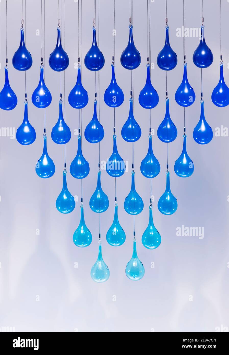 Blue glass bubble decoration tied rope hanging on ceiling Stock Photo