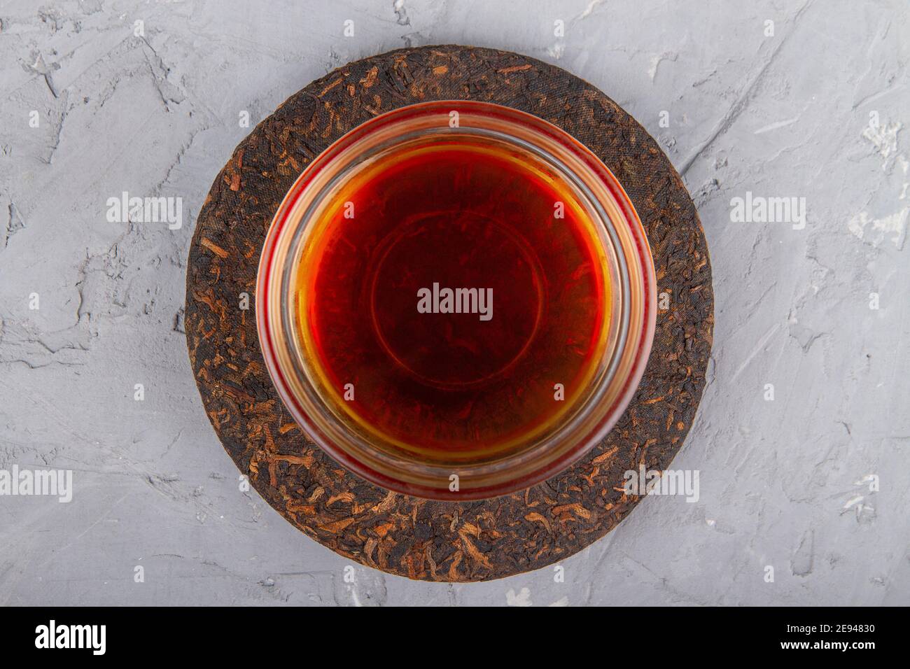 Pu erh tea cake and chinese tea cup on plaster background Stock Photo