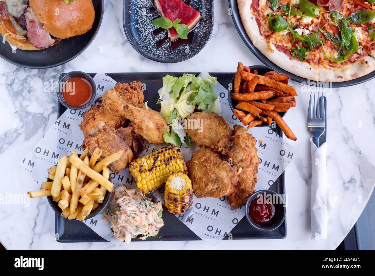 Sheffield, UK - 03 Aug 2017: Southern fried chicken and fries, pizza, cheesecake and more American diner food at OHM, Fitzwilliam Street Stock Photo