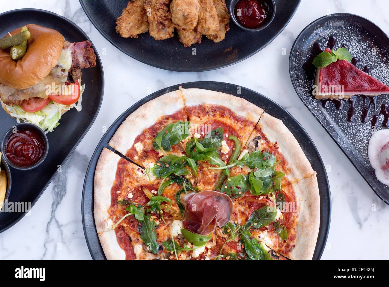 Sheffield, UK - 03 Aug 2017: pepperoni salami and rocket pizza, SFC, cheeseburger and fries and cheesecake at OHM, Fitzwilliam Street Stock Photo