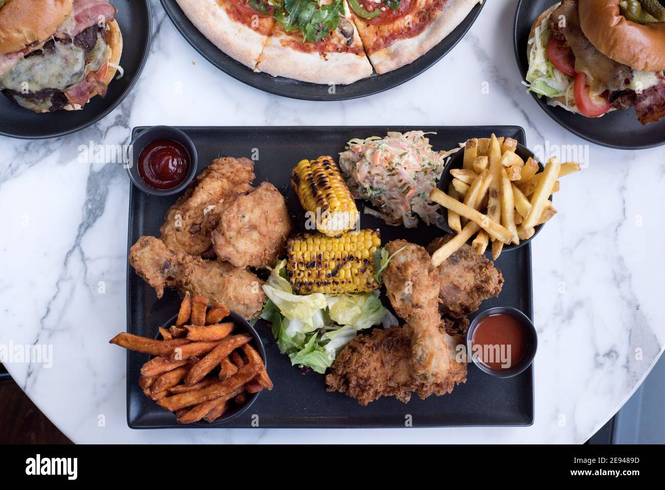 Sheffield, UK - 03 Aug 2017: Southern fried chicken and fries, pizza and burgers American diner food at OHM, Fitzwilliam Street Stock Photo