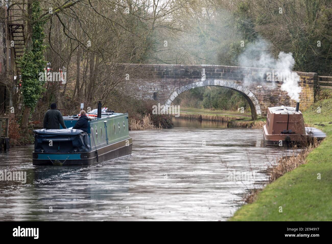 A narrowboat cutting a path through the ice on a frozen canal. Stock Photo
