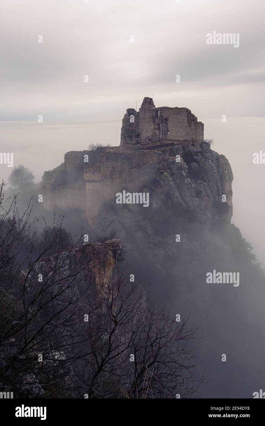 French winter landscapes. Stunning panoramic view of castle ruins Crussol. Foggy mountain landscape. Sea of clouds. Stock Photo