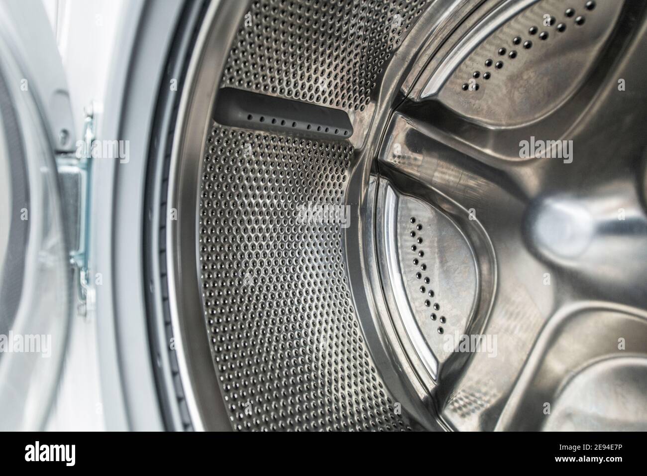 Clean Stainless Steel Laundry Machine Drum Close Up. Washing Technologies and Equipment Maintenance. Stock Photo