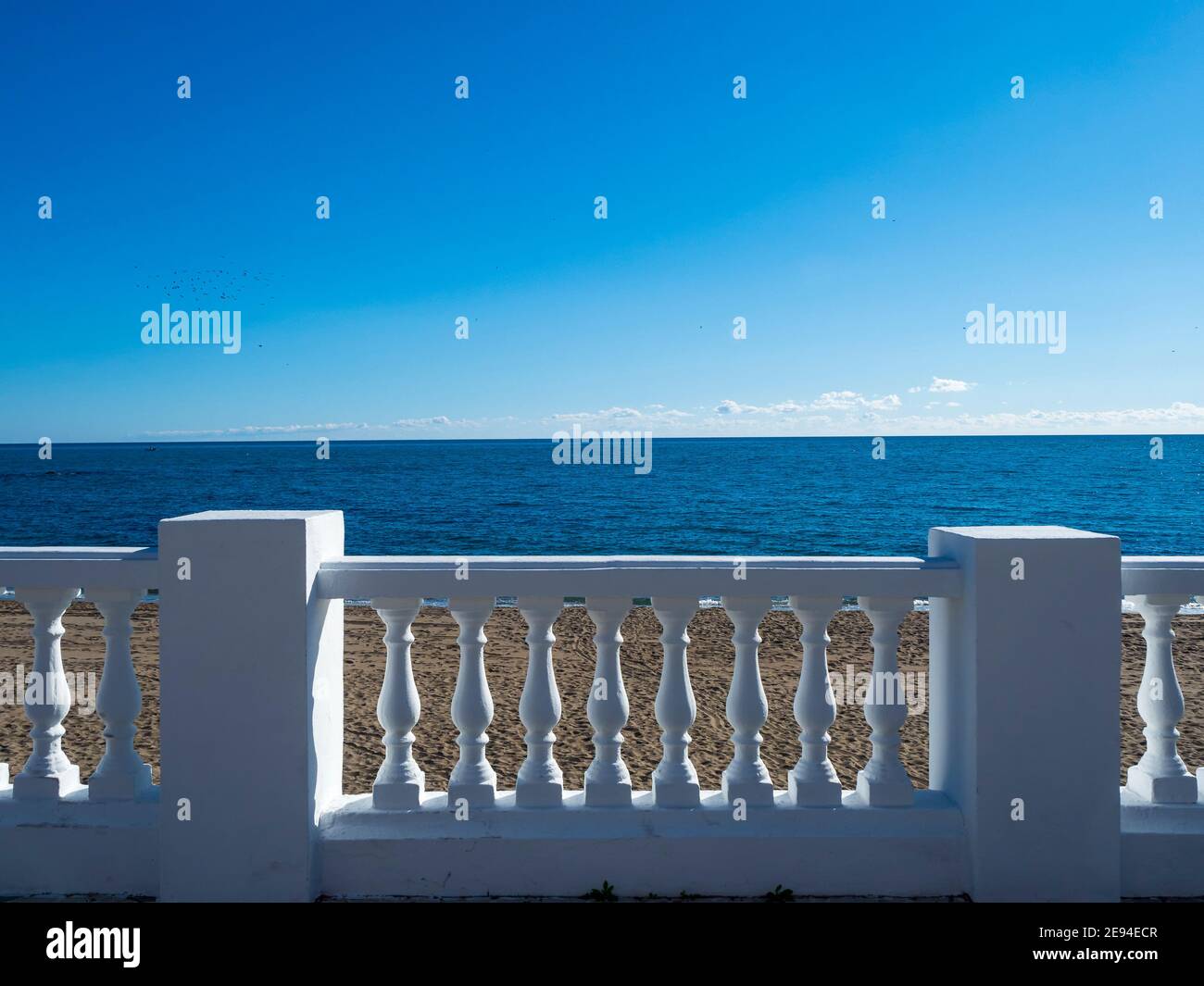 White stone balustrade in front of the sea on a sunny day with blue sky Stock Photo