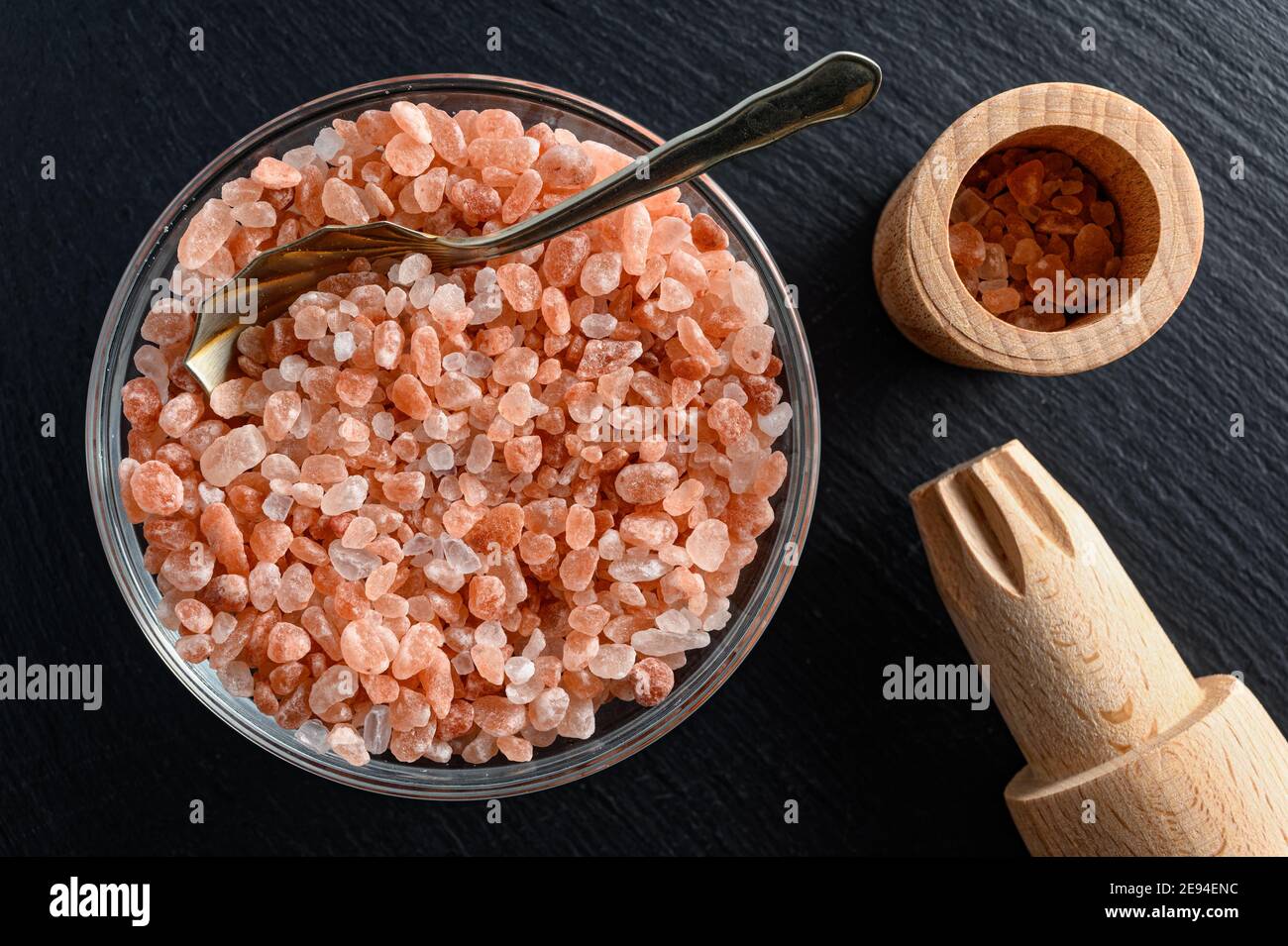 Glass bowl of himalayan salt with small spoon and wooden salt mill on ...