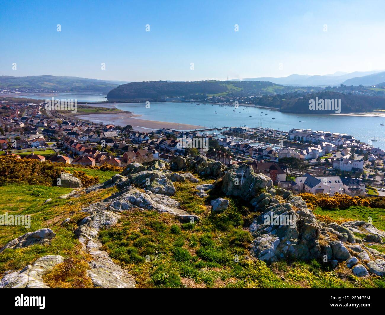 View looking down over Deganwy and the mouth of the River Conwy in Conwy North Wales from the ruins of Deganwy Castle with rocks in foreground. Stock Photo