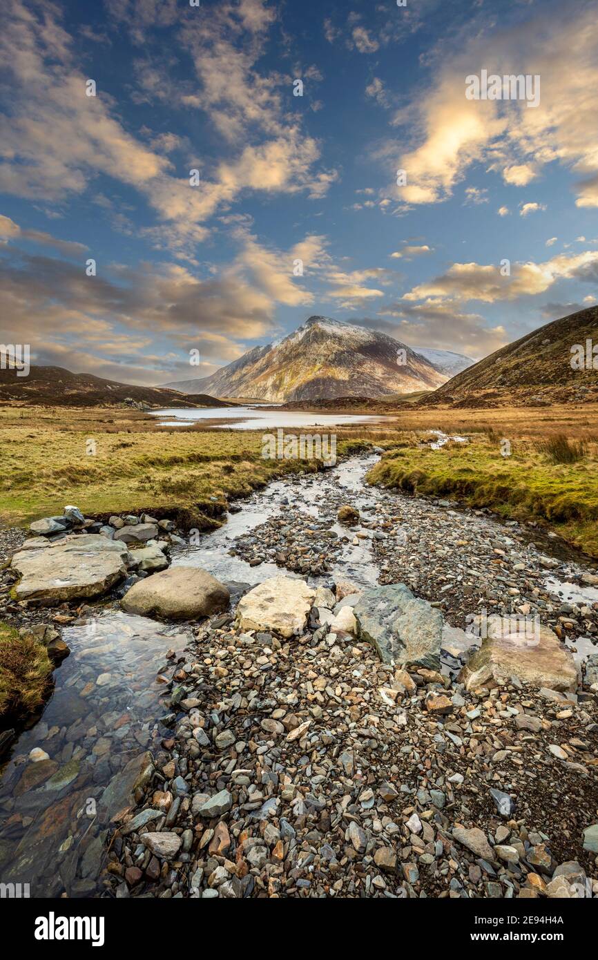 Stepping stones across a stream leading to Lake Idwal in Cwm Idwal Nature Reserve with Pen yr Ole Wen mountain in the background, Snowdonia, Wales Stock Photo