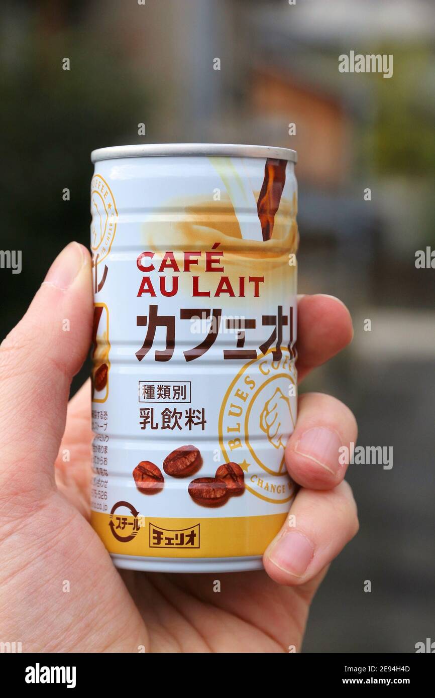 TOKYO, JAPAN - NOVEMBER 24, 2016: Person holding Cheerio brand Cafe Au Lait (Blues Coffee) canned hot coffee in Japan. Cheerio is a popular Japanese m Stock Photo
