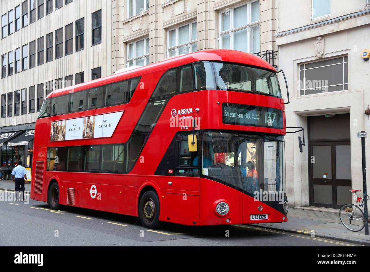 LONDON, UK - JULY 6, 2016: People ride New Routemaster bus in City of London. The hybrid diesel-electric bus is a new, modern version of iconic double Stock Photo