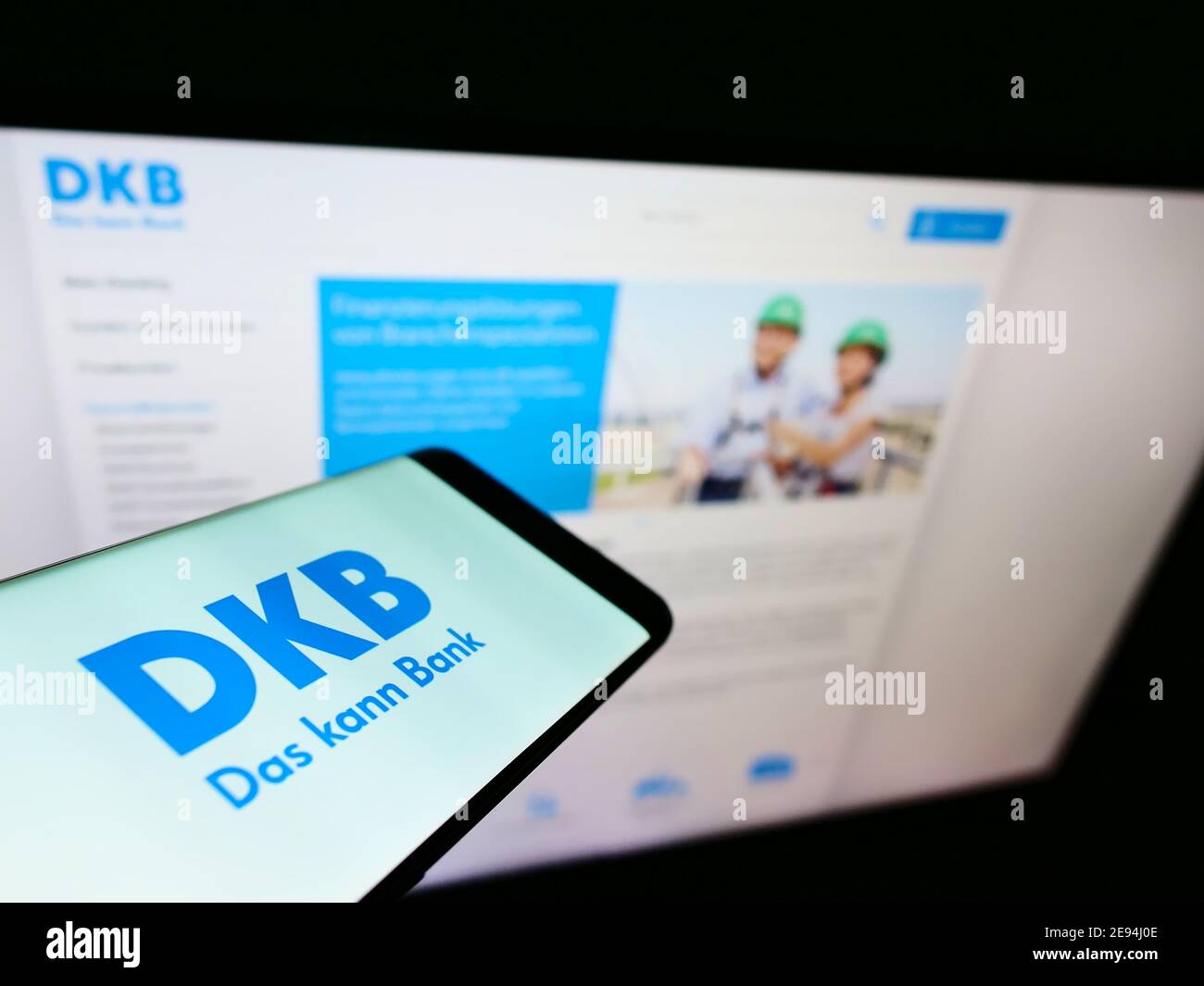 Smartphone with company logo of German direct bank Deutsche Kreditbank (DKB) on display in front of business web page. Focus on mobile phone screen. Stock Photo