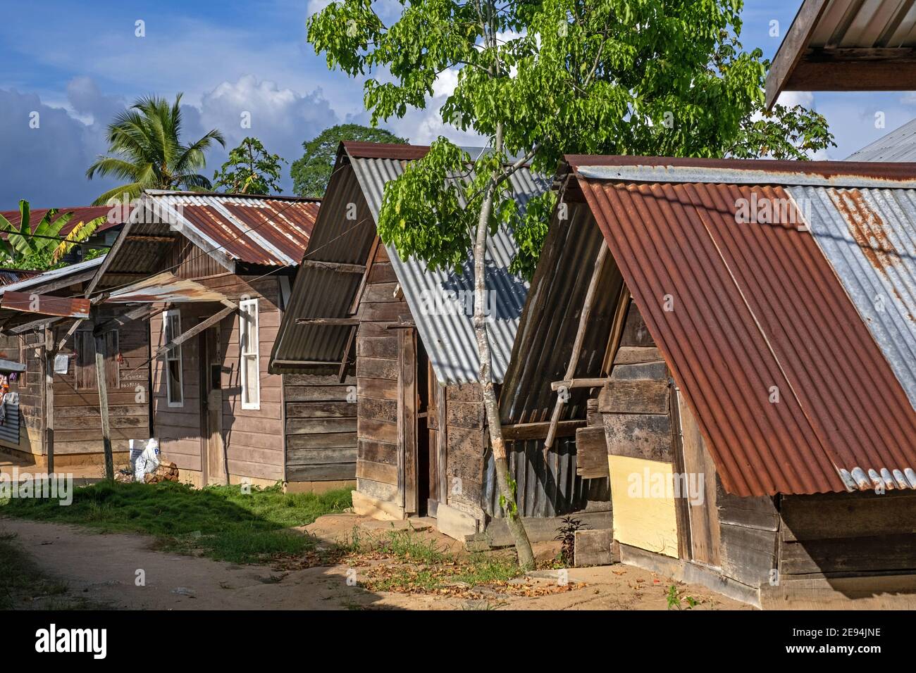 Wooden houses / huts with roofs made of corrugated sheets in the village Aurora, Sipaliwini District, Suriname / Surinam Stock Photo