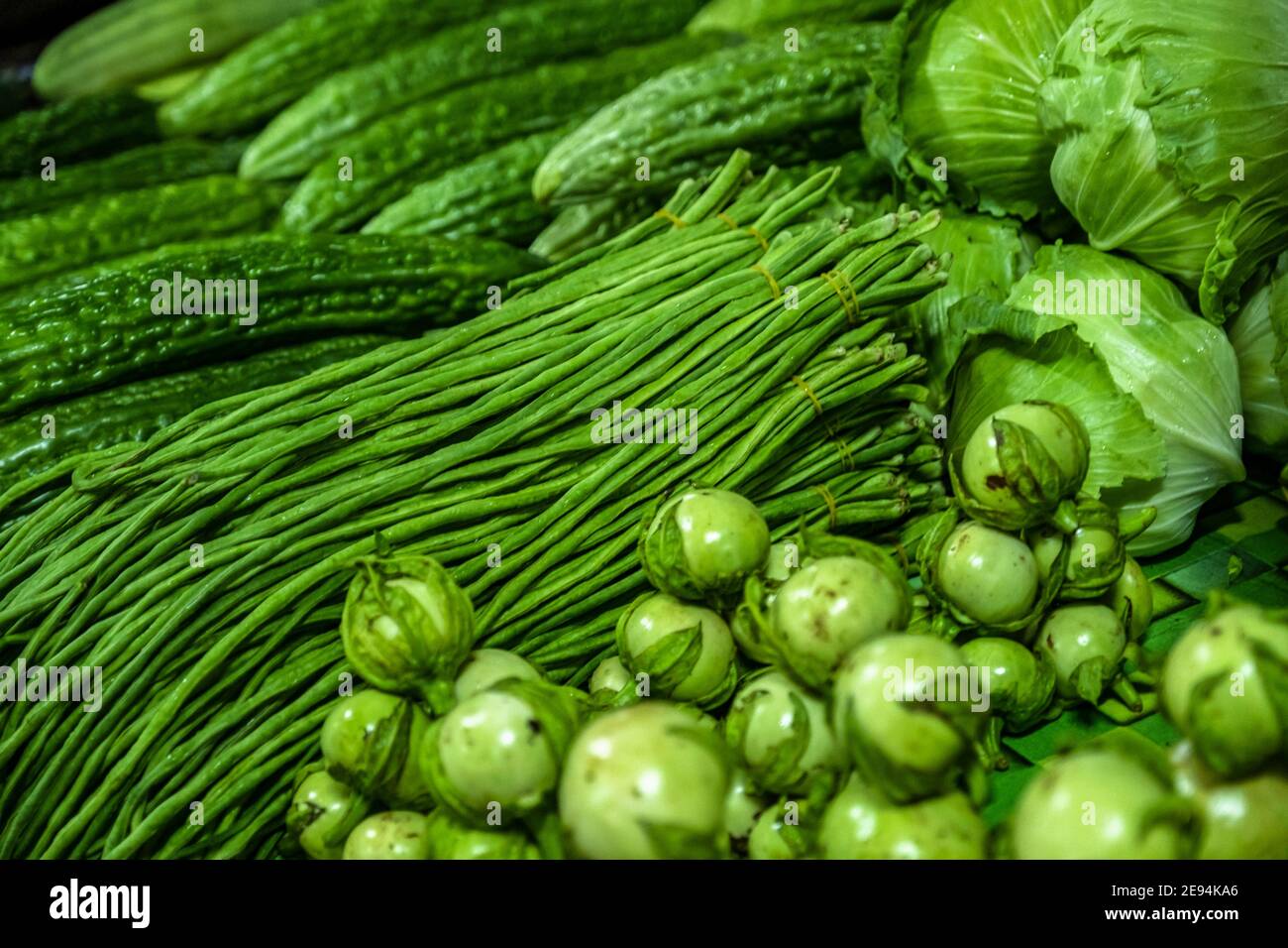 Close-up of fresh vegetables / greens / cabbages, eggplants and yardlong beans at the Centrale Markt / central market in Paramaribo, Suriname Stock Photo