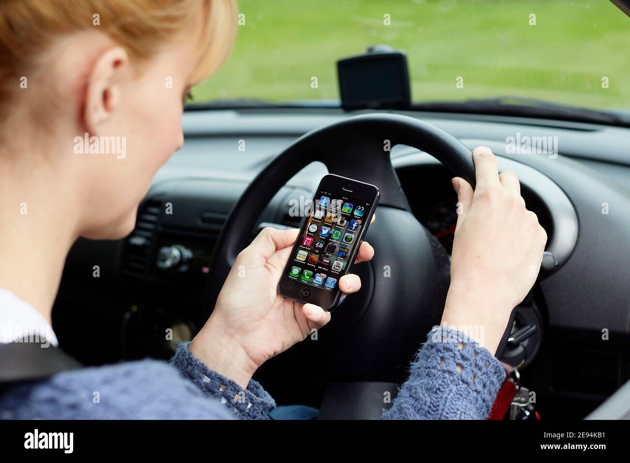 Woman using her phone whilst driving Stock Photo