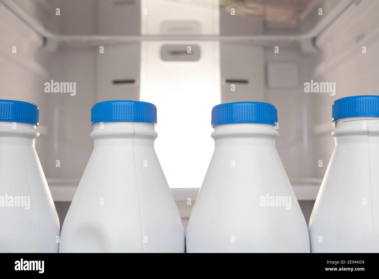 Group of plastic milk bottle stored and lined up in refrigerator door