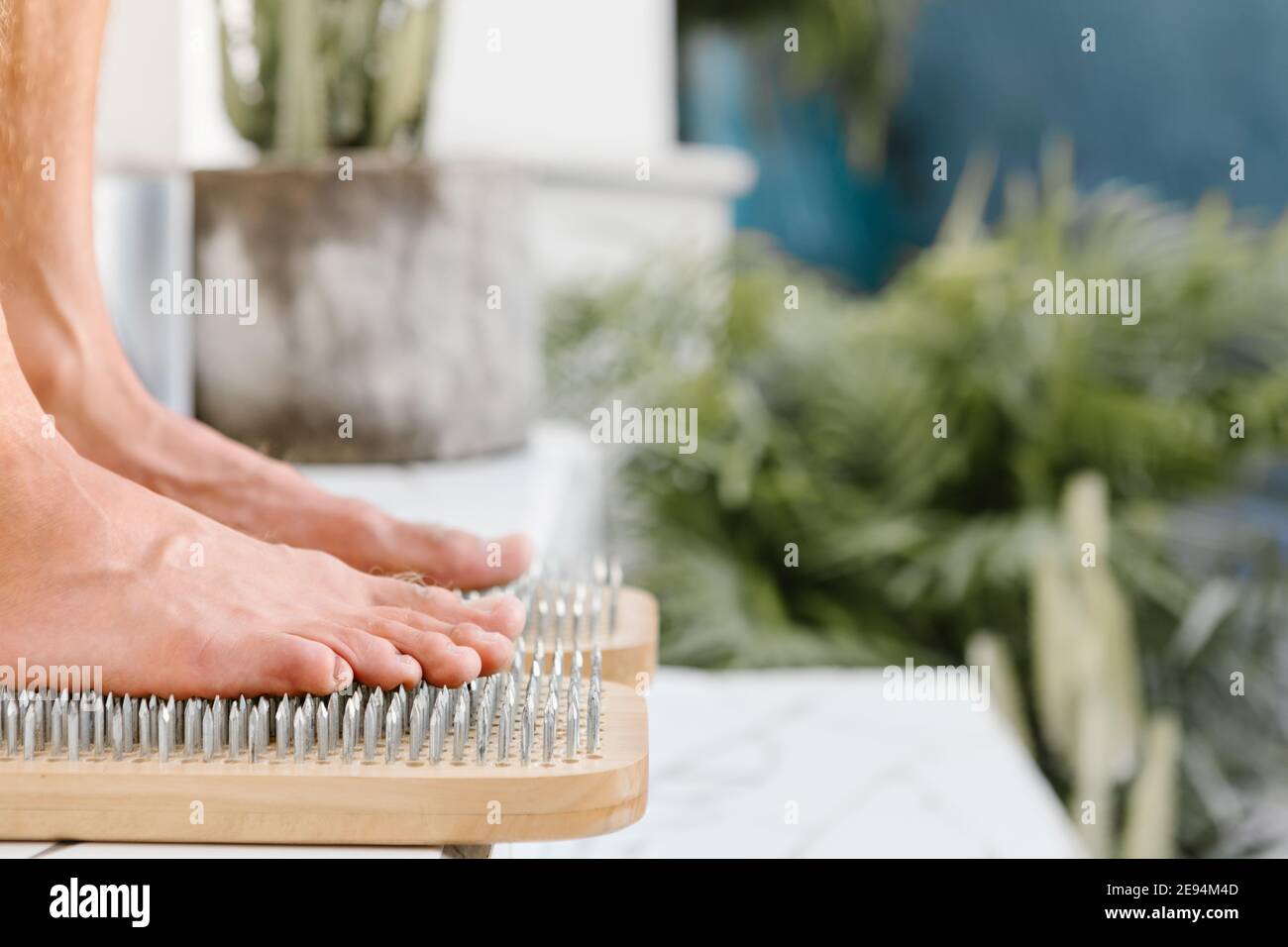 Outdoor practice of standing on nails at summer yoga retreat. Closeup