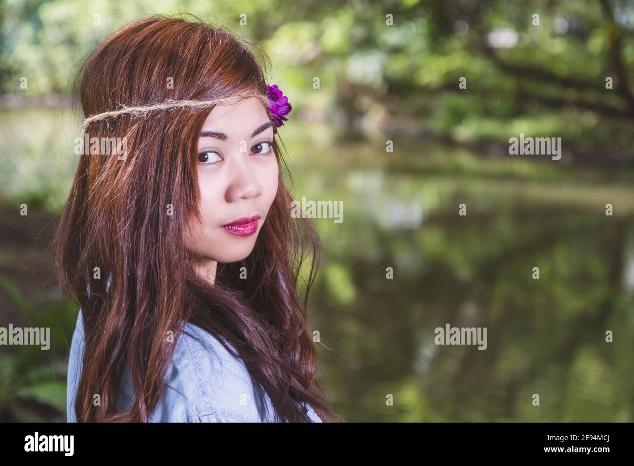 Filipina woman with a garden bokeh looking at camera Stock Photo