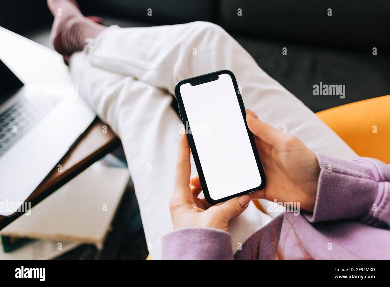 Resting Screen Woman holding a smartphone with a white screen mock up, resting on the ...