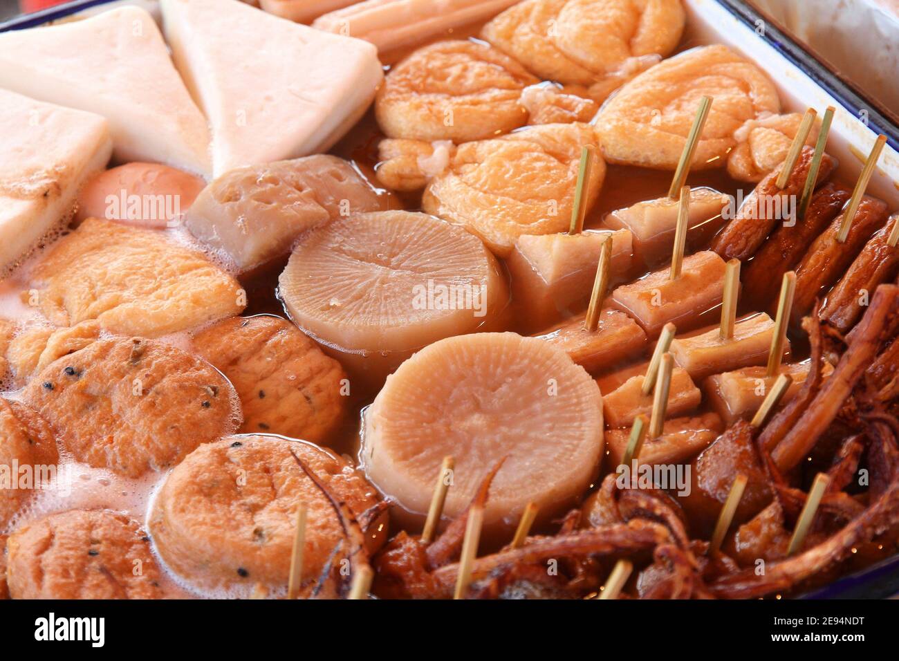 Japanese cuisine - oden food in soy broth. Typical  winter food in Japan with dumplings, tofu and daikon. Tokyo street food. Stock Photo