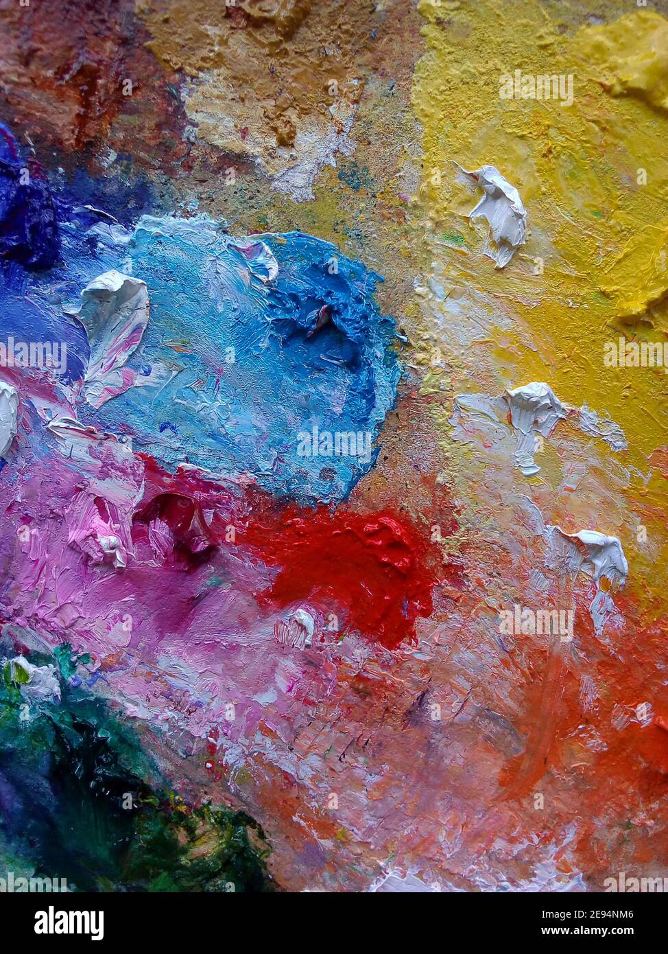 Oil, yellow, green, white, orange mixed together on a palette with