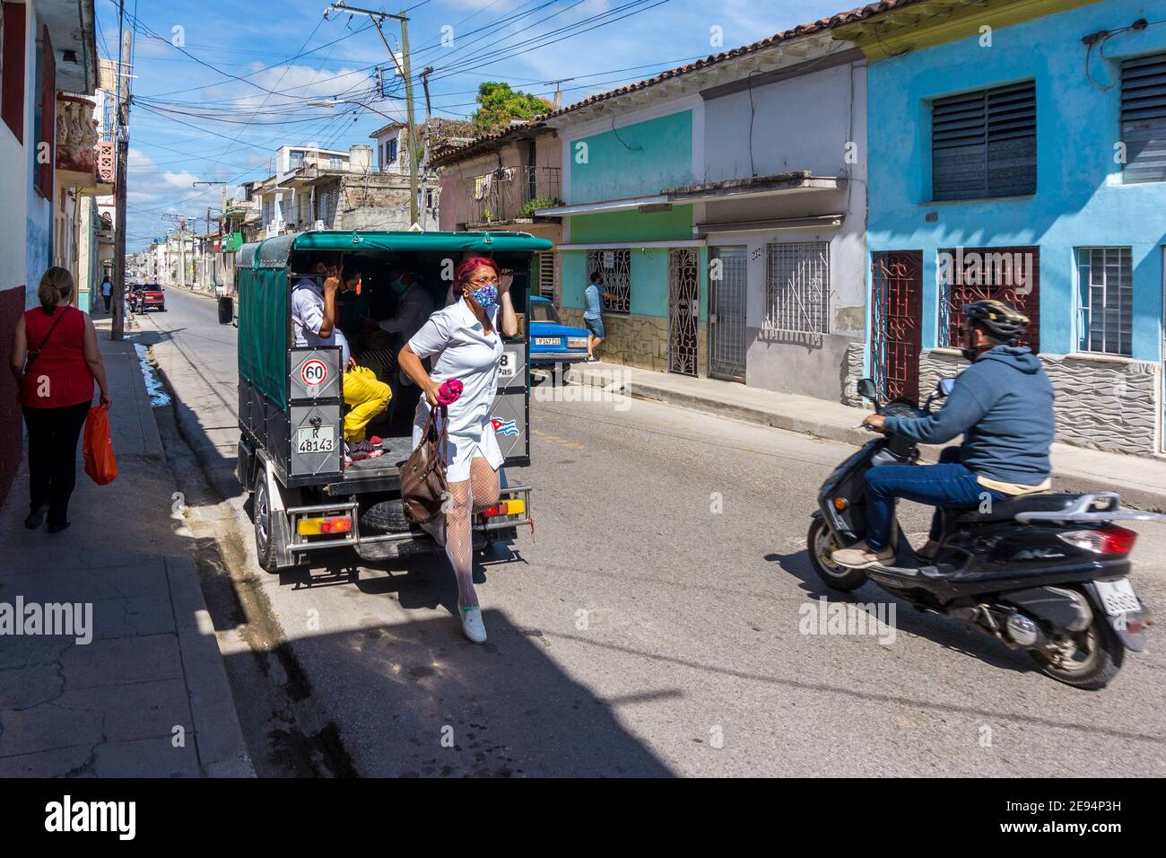 A Cuban nurse getting off a 'motoneta' after a day of work, Santa Clara, Cuba Stock Photo