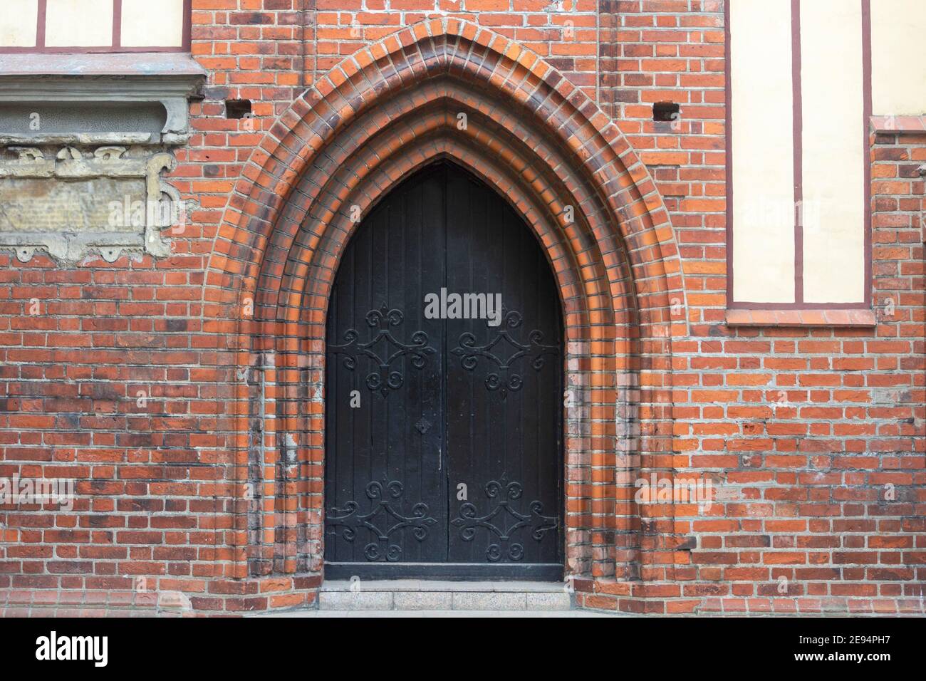 Large double doors in arch of the old castle. Ancient architecture of Europe. Stock Photo