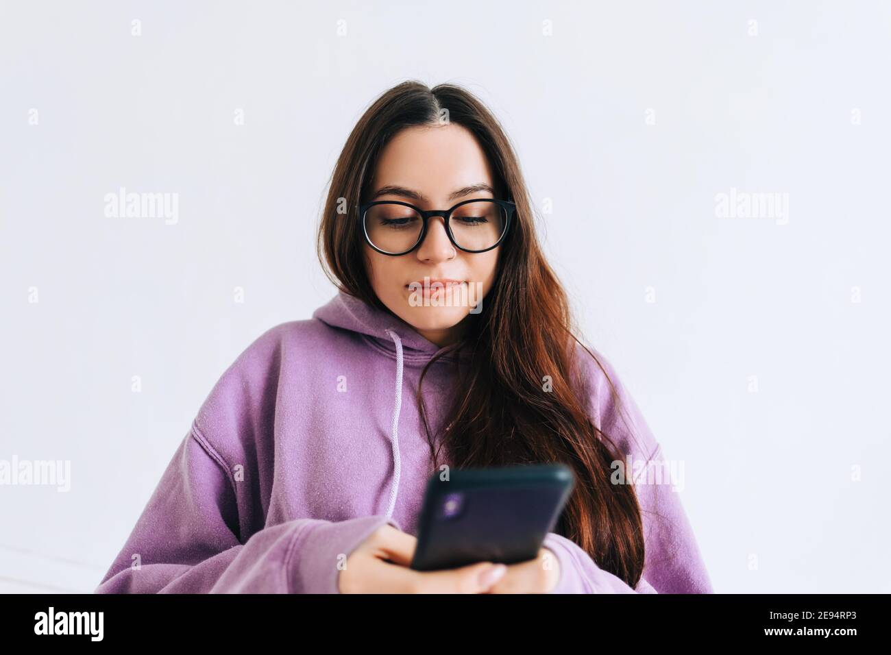 Portrait of young caucasian woman in eyeglasses using mobile phone in ...