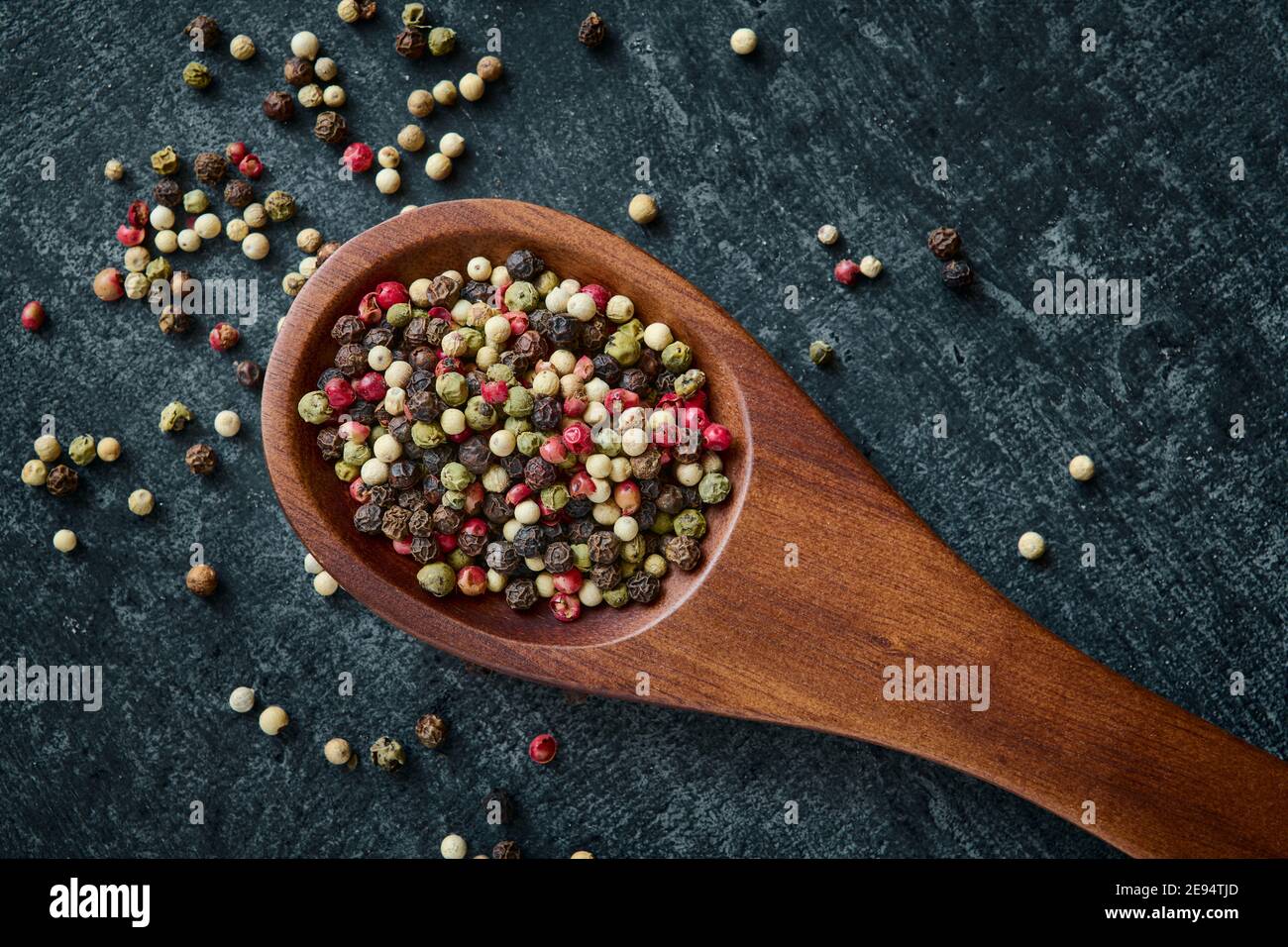 Mixed of peppercorns in a wooden spoon, top view, close up Stock Photo