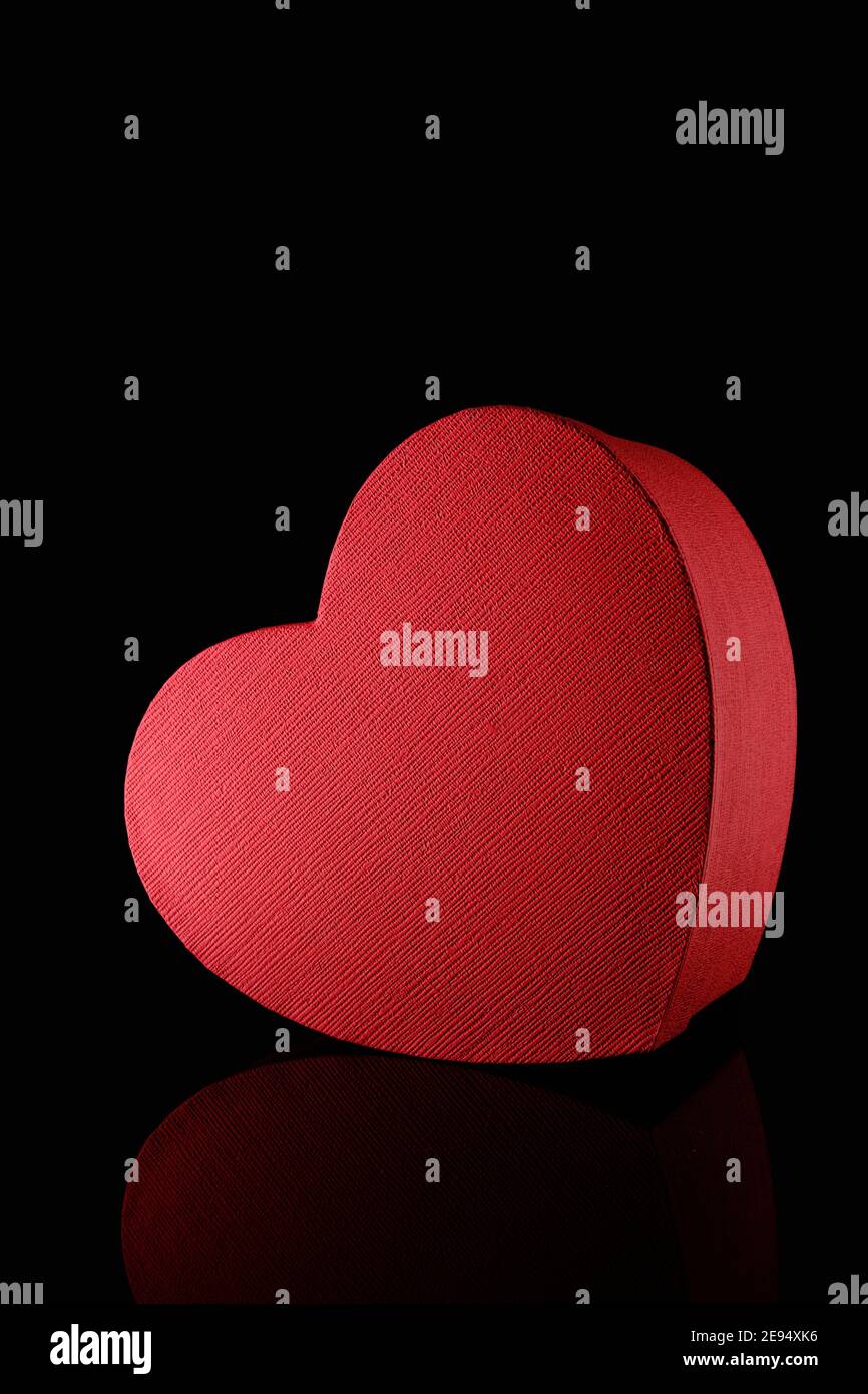 Red textured heart shape gift box on black background, gift concept Stock Photo