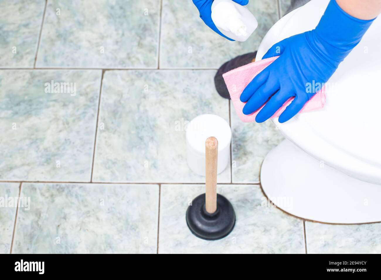 Hands in blue gloves cleaning toilet bowl with detergent with ventuz on